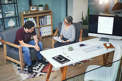 Buy stock photo Shot of a young man having a therapeutic session with a psychologist and looking upset