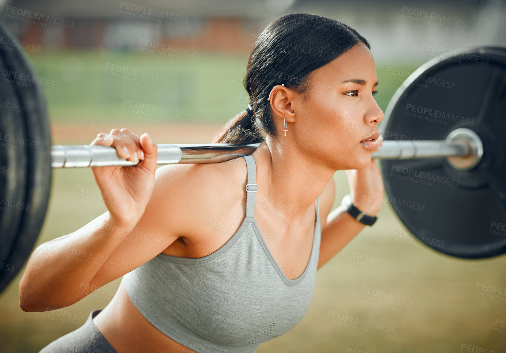 Buy stock photo Cropped shot of an attractive young female athlete exercising with weights outdoors