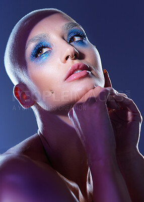 Buy stock photo Studio shot of an attractive young woman wearing edgy makeup against a blue background