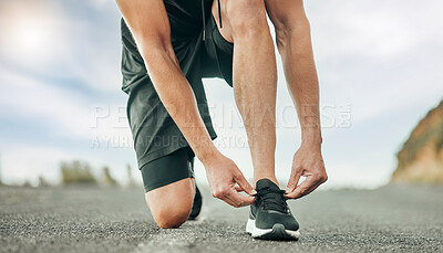 Buy stock photo Shot of an unrecognizable person tying their shoelaces before a run