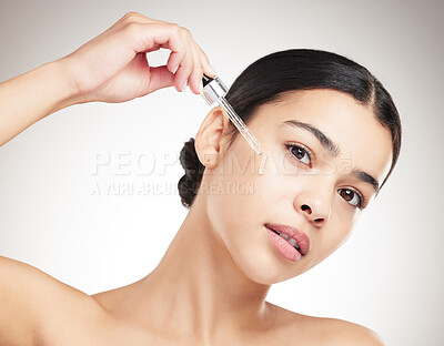 Buy stock photo Portrait, skincare or woman with serum for beauty results, shine or glow on gray studio background. Face, pipette or model apply essential oil, collagen or vitamin c cosmetic for dermatology benefits