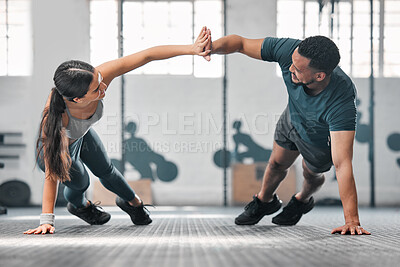 Buy stock photo Healthy, fit and active gym partners exercising together as a couple, doing pushups and a high five. Boyfriend and girlfriend training and exercising in a health club as part of their workout routine