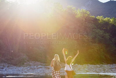 Buy stock photo Women, back or sunshine with freedom by lake for holiday, hiking trip or break in nature. Young, female person or friends with sunlight by water, river or pond for tourism, travel or carefree journey