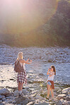 Young women taking photos of each other with a smartphone and digital camera next to a river during a hike.Two friends taking photos of each other with a camera and cellphone on a hike.