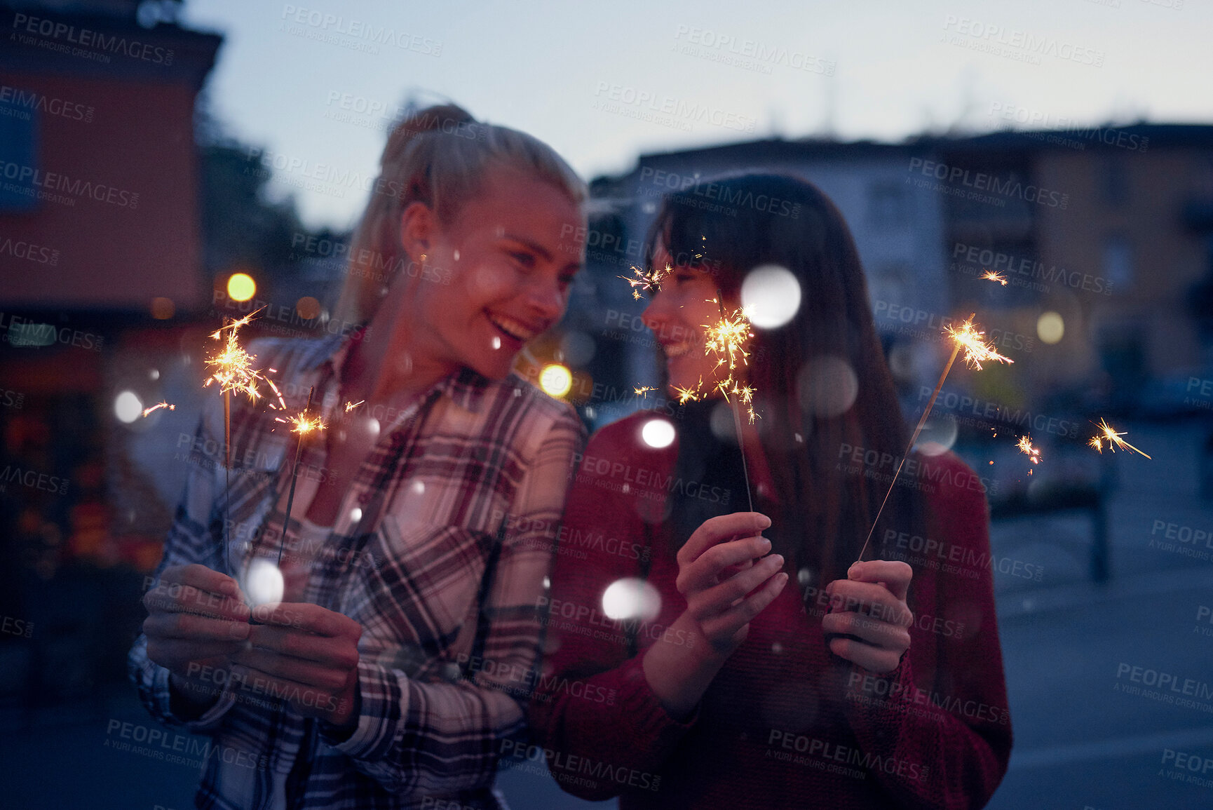 Buy stock photo Happy women, night and celebration with sparklers for new year, party or festive season in city. Young, female person or friends with fireworks in late evening for holiday, weekend or event in town