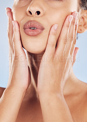 Buy stock photo Woman, closeup and touch in studio for skincare, beauty and cosmetics with healthy skin, glow and lips. Model, mouth and hands on blue background for dermatology, aesthetic and facial transformation