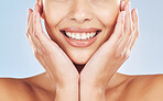 Closeup face beautiful young mixed race woman. Attractive female smiling in studio isolated against a blue background. Practising good oral and dental hygiene for healthy mouth, teeth and gums