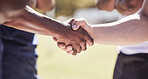 Closeup two opponent rugby teams shaking hands before or after a match outside on a field. Rugby players sharing a handshake to show respect and sportsmanship. A mutual understanding of the game