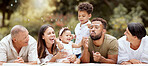 Happy, smile and big family blowing bubbles in a garden on a summer picnic in Puerto Rico. Happiness, grandparents and parents with children playing, having fun and relaxing together in the park 