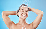 Hair care, smile and Asian woman in the shower for grooming, hygiene and morning routine against a blue studio background. Wellness, happy and beauty model washing hair with foam from shampoo