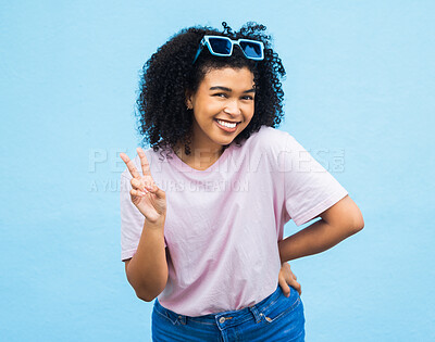 Buy stock photo Black woman, peace sign and portrait of a model isolated with blue background in a studio. Young, happy smile and v hand gesture of a person feeling relax with happiness alone with casual style