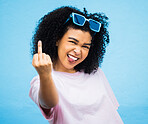 Portrait, middle finger and hand, emoji and black woman in studio, rude and carefree on a blue background. Face, rebel and hands by girl for message, attitude and expression, personality and isolated