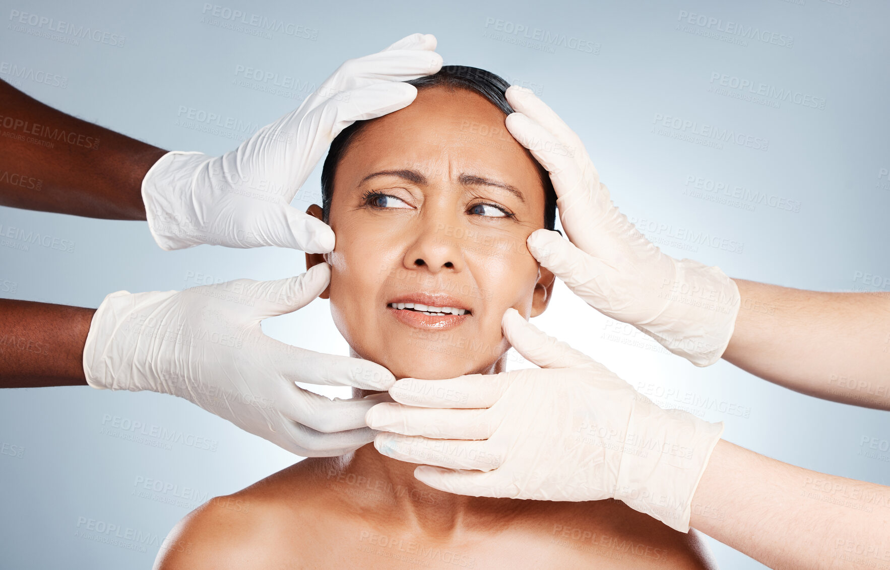 Buy stock photo Plastic surgery, confused and face of woman with hands from doctors isolated on blue background. Skincare, check and mature person worried about facelift, cosmetic and facial surgeon professionals