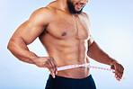 Black man, exercise and body, weightloss and measuring tape  with abs, health and active lifestyle on blue background, Shirtless male bodybuilder, smile and fitness with diet, healthy and strong