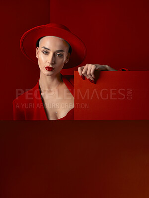 Buy stock photo Portrait, red fashion and mockup with a woman on a studio background for marketing, advertising or branding. Luxury, aesthetic style or trendy young female in a hat standing with empty or blank space