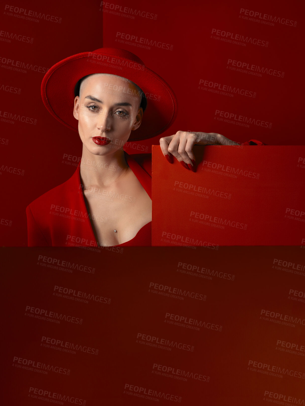 Buy stock photo Portrait, red fashion and mockup with a woman on a studio background for marketing, advertising or branding. Luxury, aesthetic style or trendy young female in a hat standing with empty or blank space