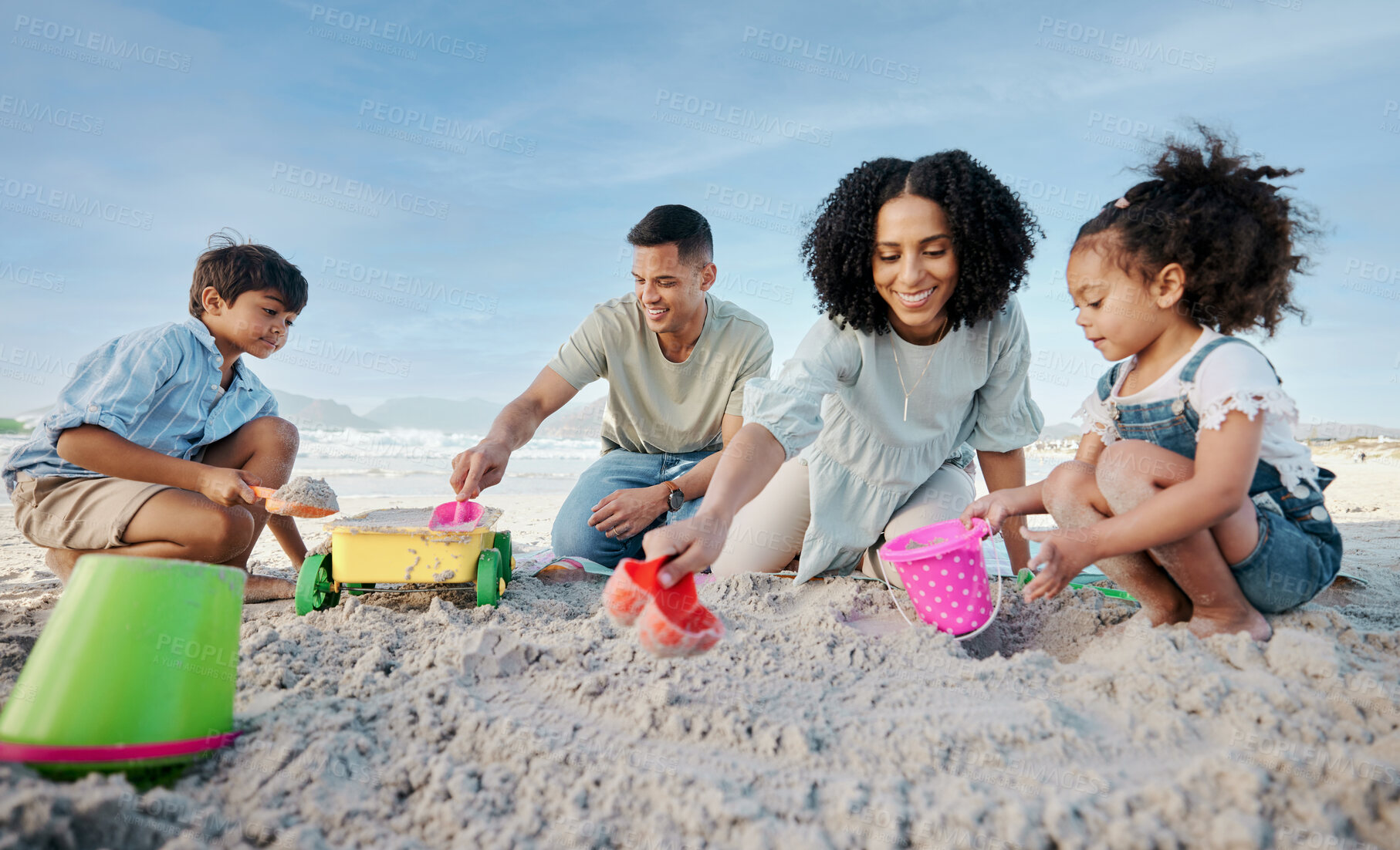 Buy stock photo Parents, kids and sandcastle at beach, bucket and digging for bonding, outdoor and vacation in summer. Mom, dad and siblings with plastic toys, sand or construction game for holiday, happy and ocean