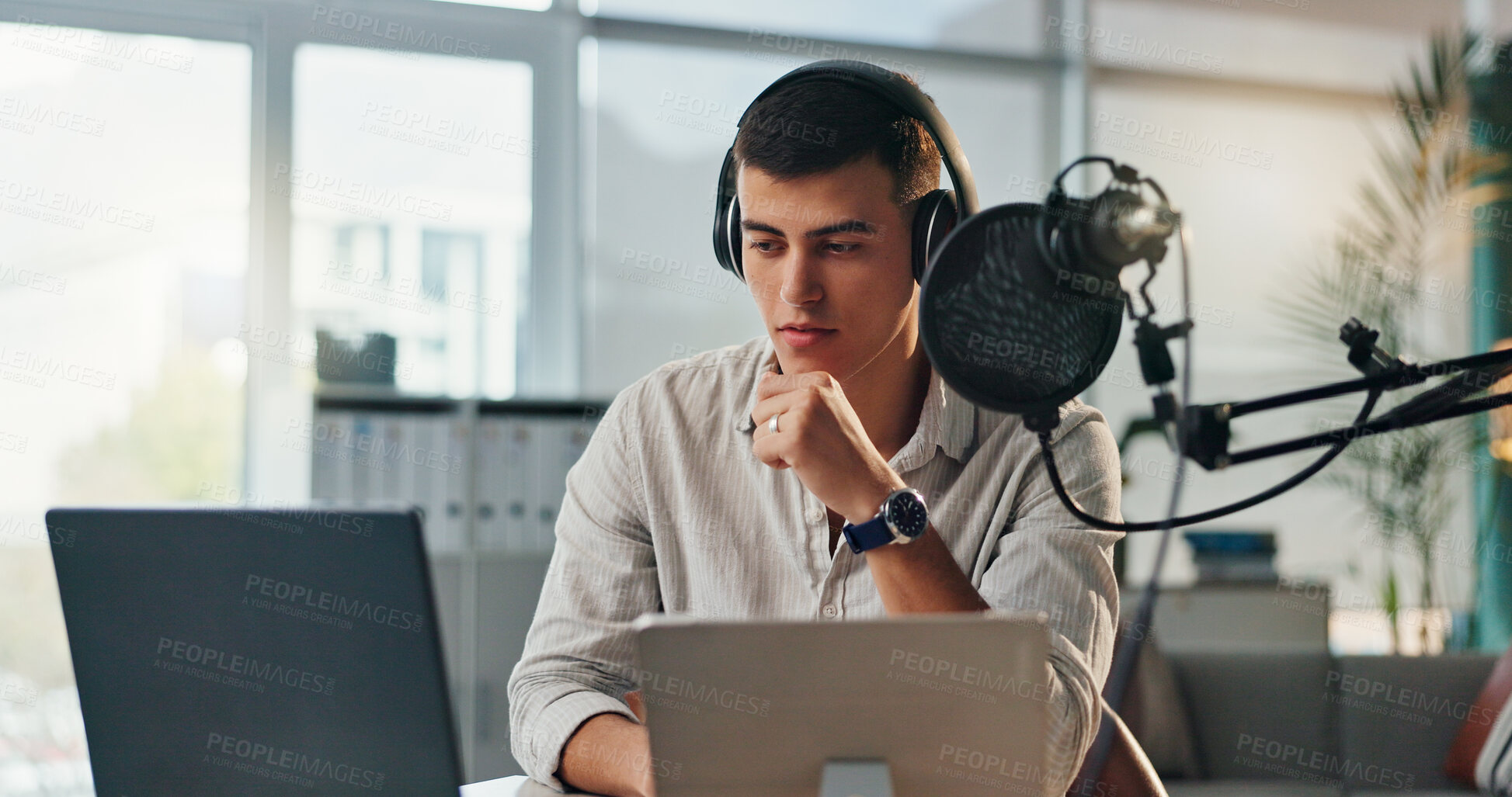 Buy stock photo Podcast, presenter and radio show with laptop and reporter man with research for live streaming. Content creator, microphone and headphones with influencer, broadcast planning and dj in home studio