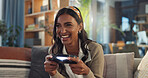 Indian woman, home and happy with video game in sofa at living room for fun and esports challenge . Female person, excited and smile with joystick or controller on couch for entertainment on break