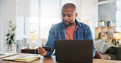 Buy stock photo Black man, home and serious on laptop with debit card for online shopping, ecommerce and purchase. Male person, internet banking and buying or payment with credit verification, check and security