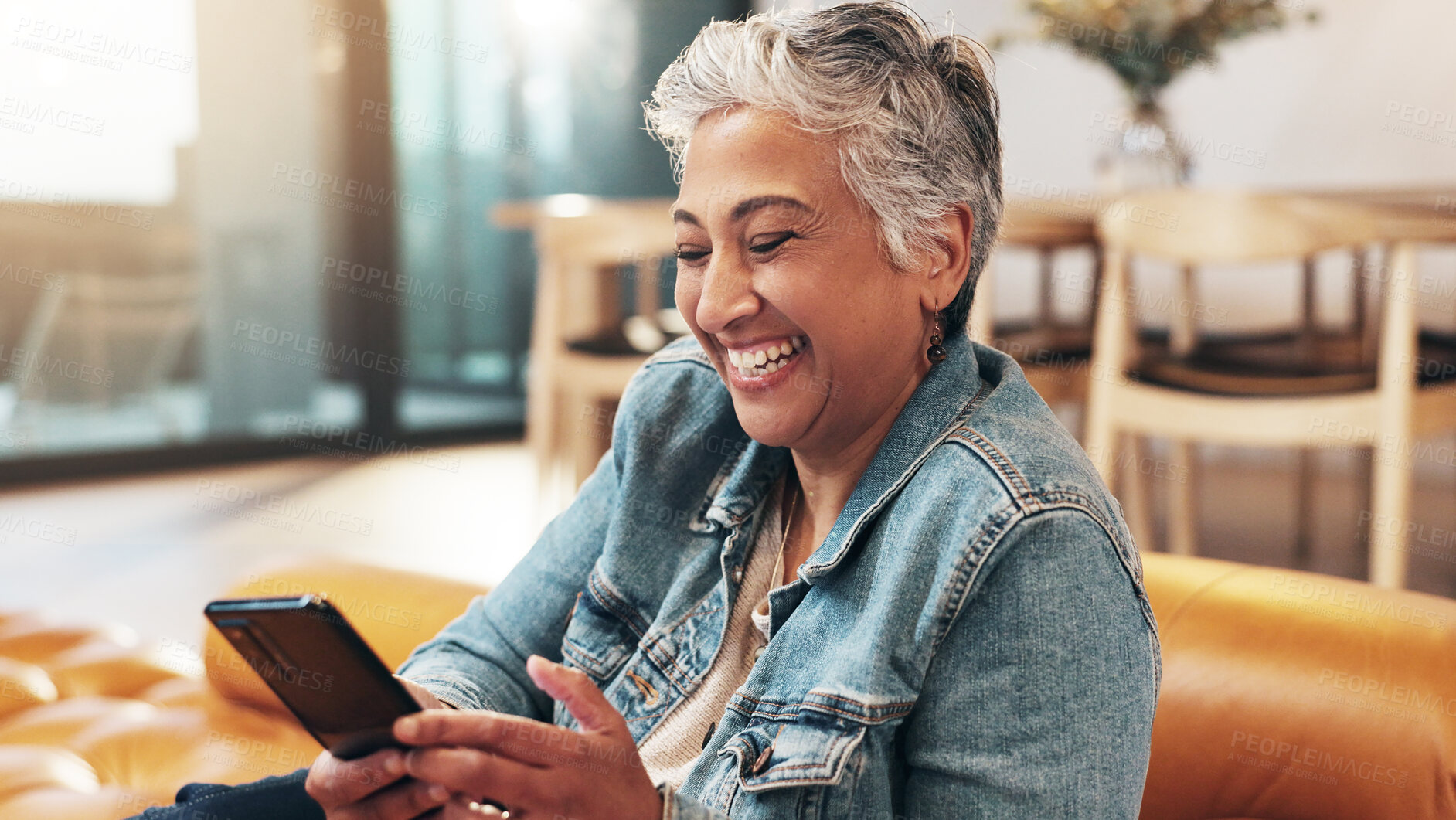 Buy stock photo Mature, woman and laughing at phone on sofa for text message, communication or fun dating site in home. Happy person, relax and smartphone for social media, comedy video and blog post joke on couch