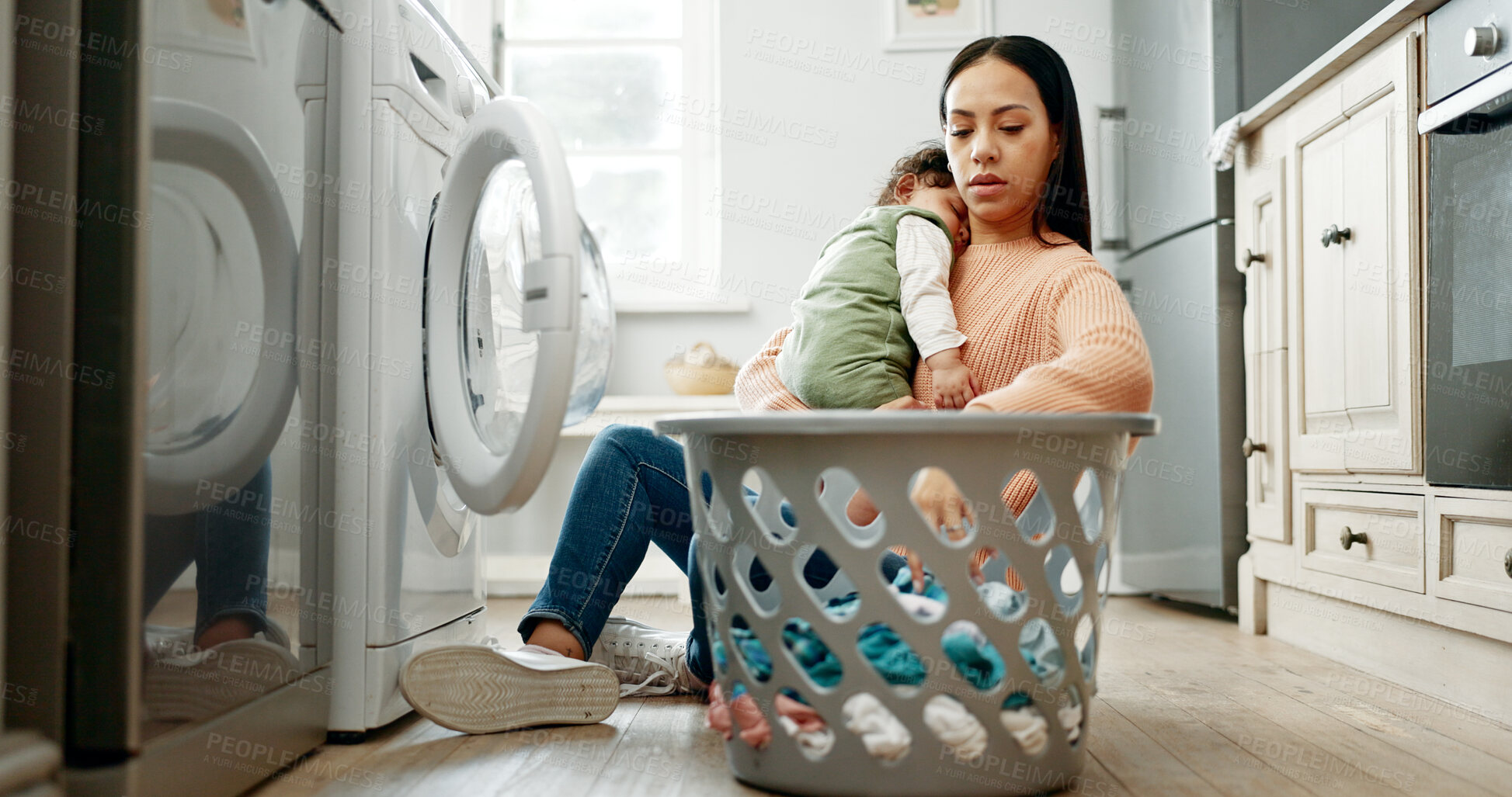 Buy stock photo Mother, baby and basket in kitchen for laundry, housekeeping and motherhood in house with sleeping child. Woman, newborn and tired with washing machine for cleaning clothes, parenthood and burnout