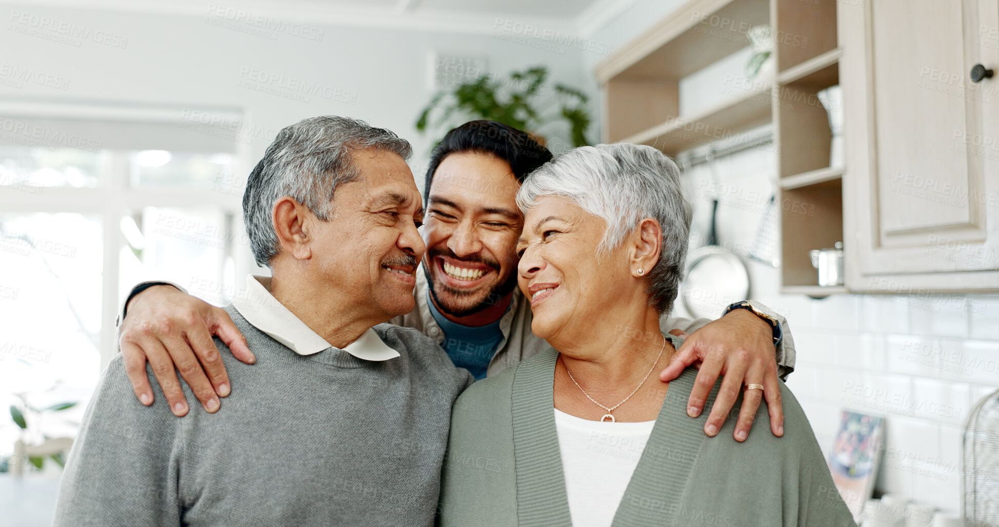 Buy stock photo House, adult son and hug parents with weekend visit, welcome or bonding moment with smile, love or care. Happy family, senior people and embrace man in home for hello, comfort or affection in kitchen