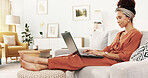 African woman, laptop and relax on sofa for movie, communication and social media with writing blog. Female person, technology and happy on couch for film, app subscription and reading news in house