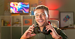 Happy man, portrait and gamer with headphones for online tournament, streaming or esport at home. Young, male person or streamer with smile or headset at night for console or computer gaming at house