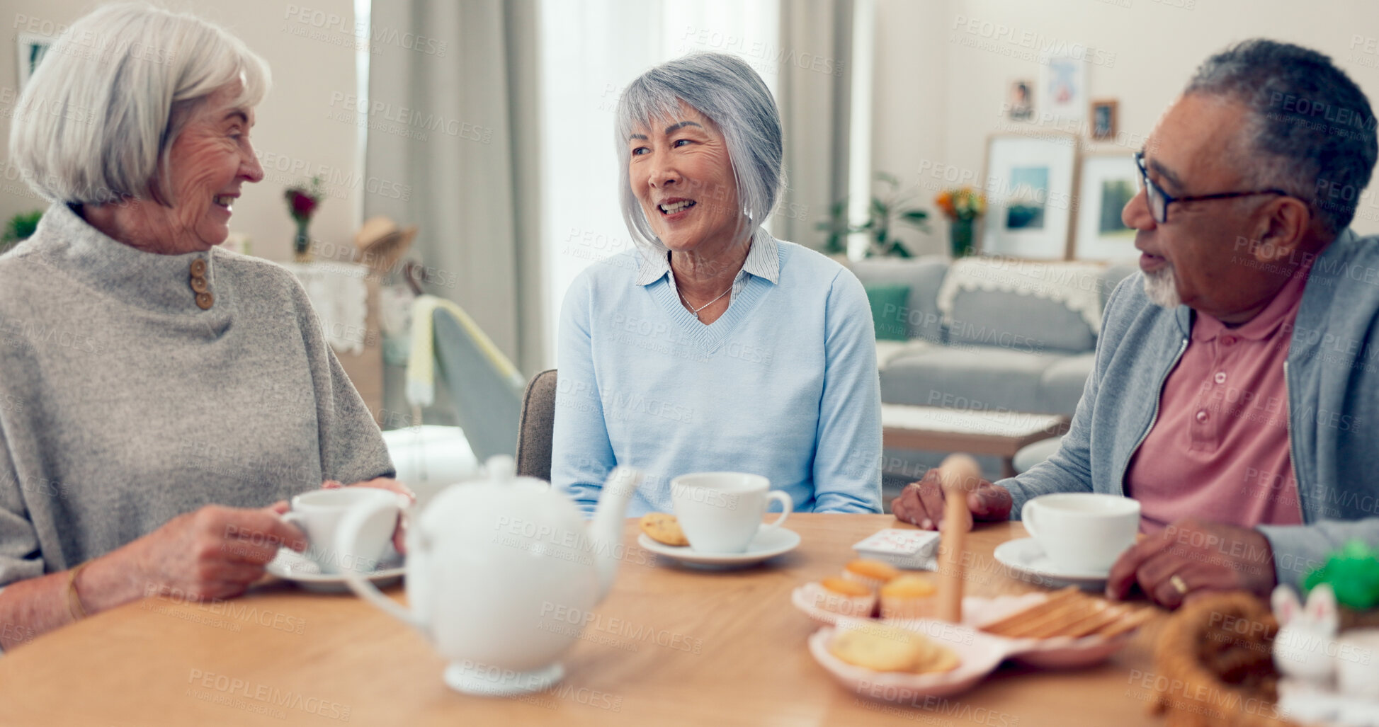 Buy stock photo Talking, tea and senior friends at table for conversation, snacks and retirement together in house. Happy group, party and man speaking with elderly women for breakfast, communication and bonding