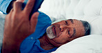 Senior, man and  relax with phone on bed for communication, reading email and typing of contact. Elderly, person and texting for conversation, social media and online news of retirement at house