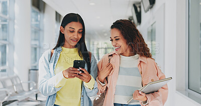 Buy stock photo Friends, smile and phone in university for gossip, storytelling and excited for personal message. Students, laughing and mobile in lobby for social media, celebrity news and secrecy in relationship