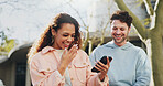 Phone, laughing and couple outdoor on date, travel or reading funny meme in city together. Mobile, happy man or interracial woman at park on app online for joke, watch video or comedy on social media