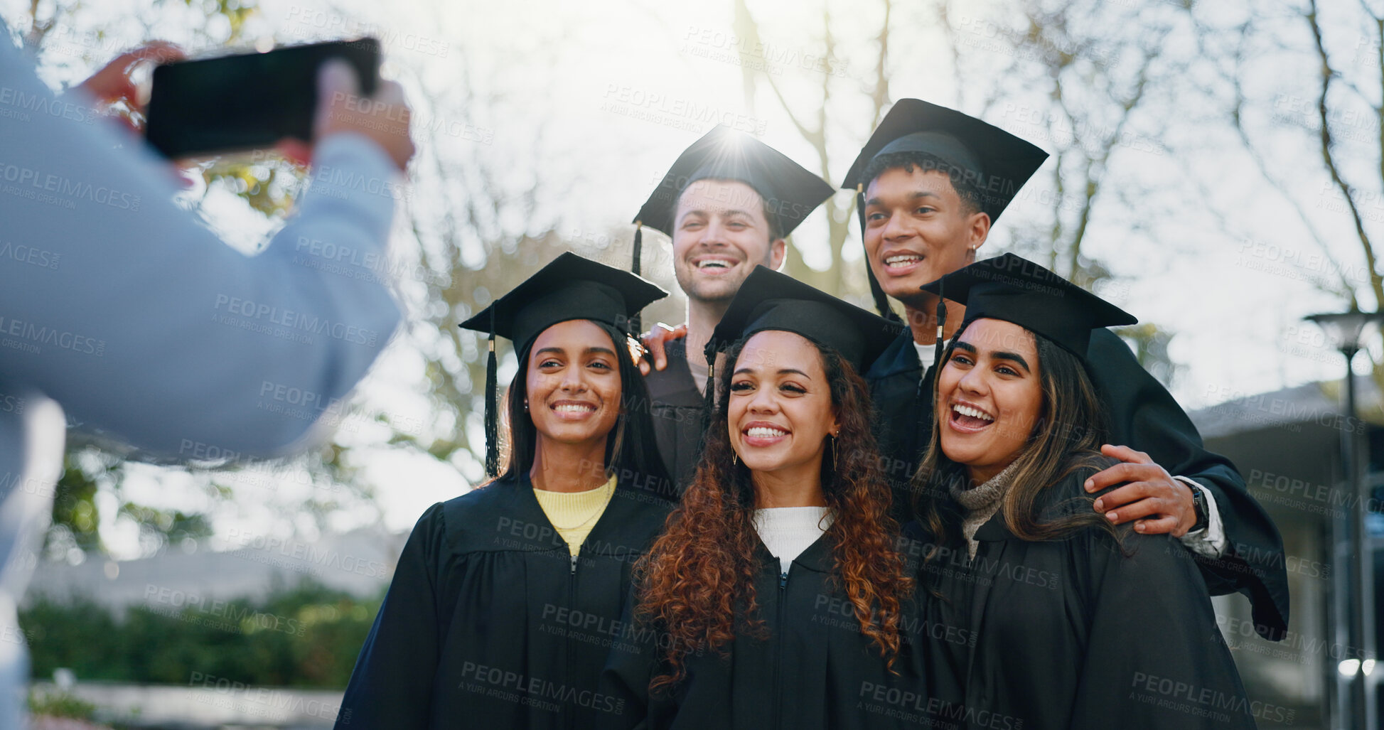 Buy stock photo Students, graduation and smile on campus for photography, support and happy for achievement. Friends, hug and excited at celebration for memories, academic success and taking picture for yearbook