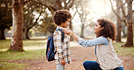 Love, mother and kid with backpack in forest for back to school, getting ready and fixing shirt for support in education. Family, woman and help boy in woods for morning commute and learning journey