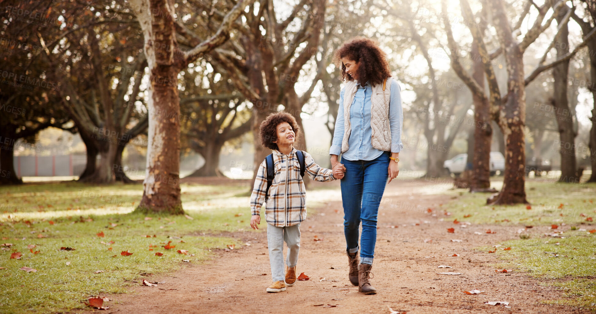 Buy stock photo Holding hands, mom and child walking to school with safety, bonding and backpack in park trees together. Happy, woman and son on outdoor garden path for morning commute with love, trust and support