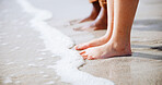 Feet, sand and couple at the beach for holiday and summer vacation with travel by ocean. Hawaii, together and tropical with sea water and people legs on an island with freedom and sunshine outdoor