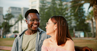 Buy stock photo Smile, love and couple on bench in park for outdoor fun, bonding and care with interracial relationship. Romance, happy man and woman on date with laughing, relax and calm weekend holiday together