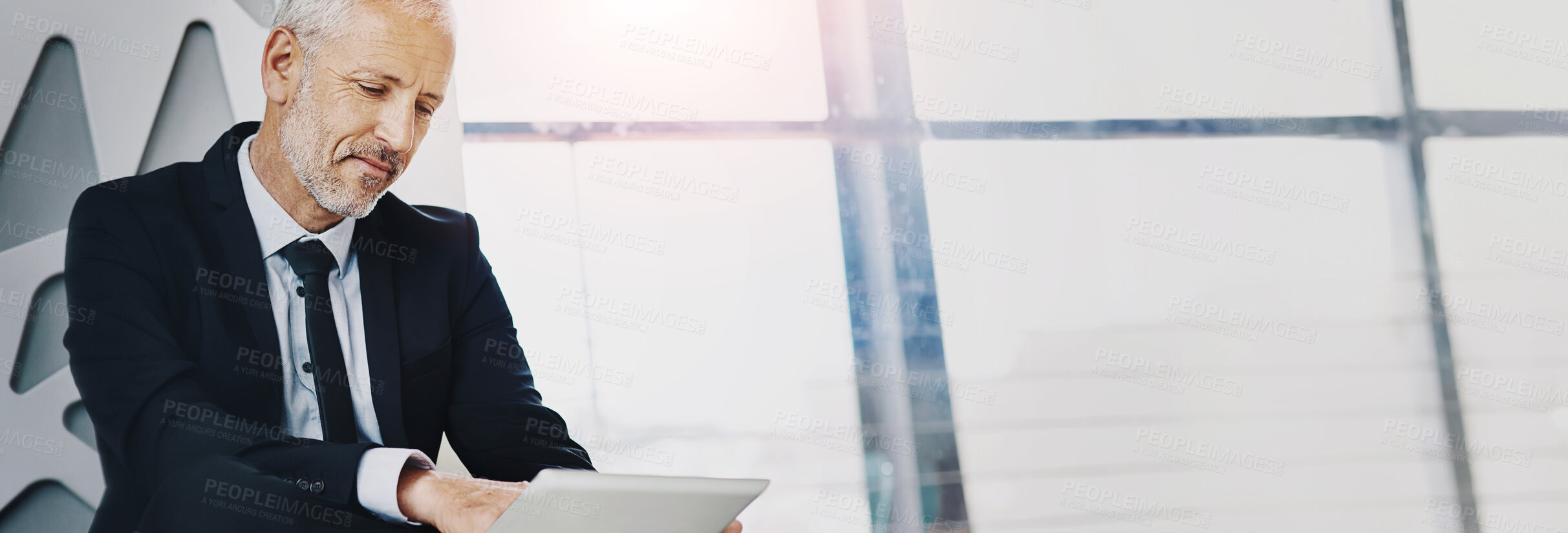 Buy stock photo Cropped shot of a mature businessman working on a digital tablet in an office