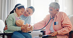 Pediatrician, child and mom at consultation with stethoscope of mature woman and teddy with health check. Smile, clinic and healthcare with exam, young girl and wellness with family doctor and talk