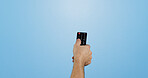 Studio, hand and person with remote for change, power control or channel navigation for television. Mockup space, man or equipment by blue background for menu access, adjust volume or switch programs