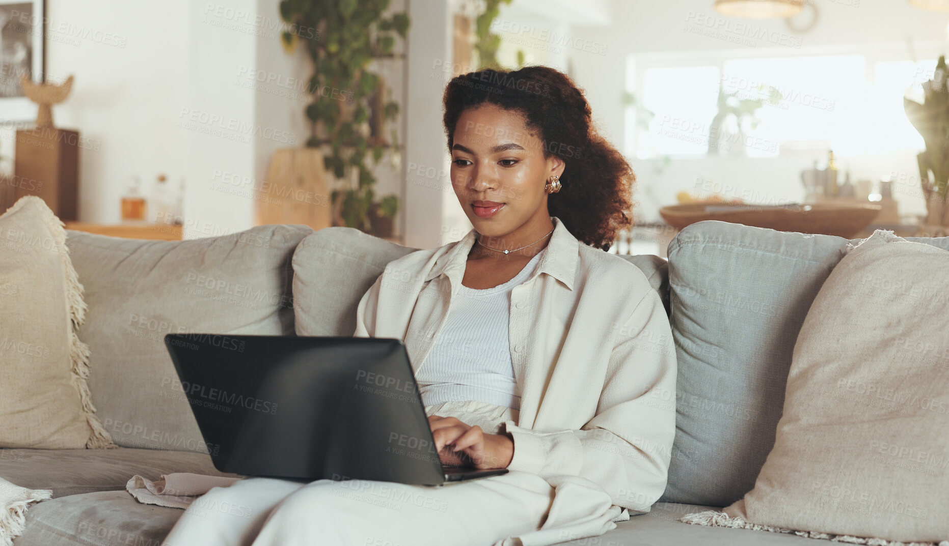 Buy stock photo Laptop, remote work and website with business woman on sofa in living room of home for research. Computer, planning and typing with African employee in apartment for administration or information