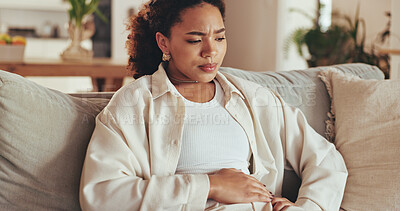 Buy stock photo Stomach ache, pain and sick woman in home with diarrhea, period cramps or food poisoning. Abdomen, gas or African person with constipation, stress or thinking of menstrual cycle on living room sofa