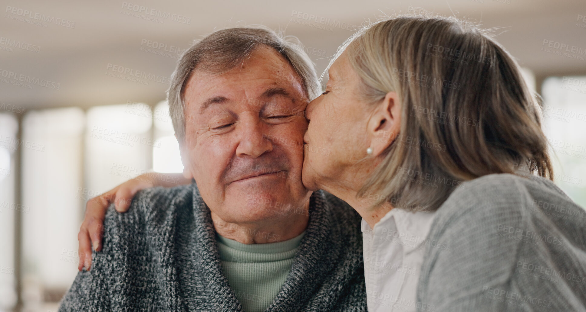 Buy stock photo Senior woman, man and kiss cheek in home with smile, hug and eyes closed with bonding in retirement. Couple, embrace and happy with love with memory, connection and relax together in morning at house