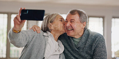 Buy stock photo Senior couple, selfie and kiss in home, photography and online for social media post in living room. Elderly people, happy and laugh for affection in relationship, love and profile picture for memory