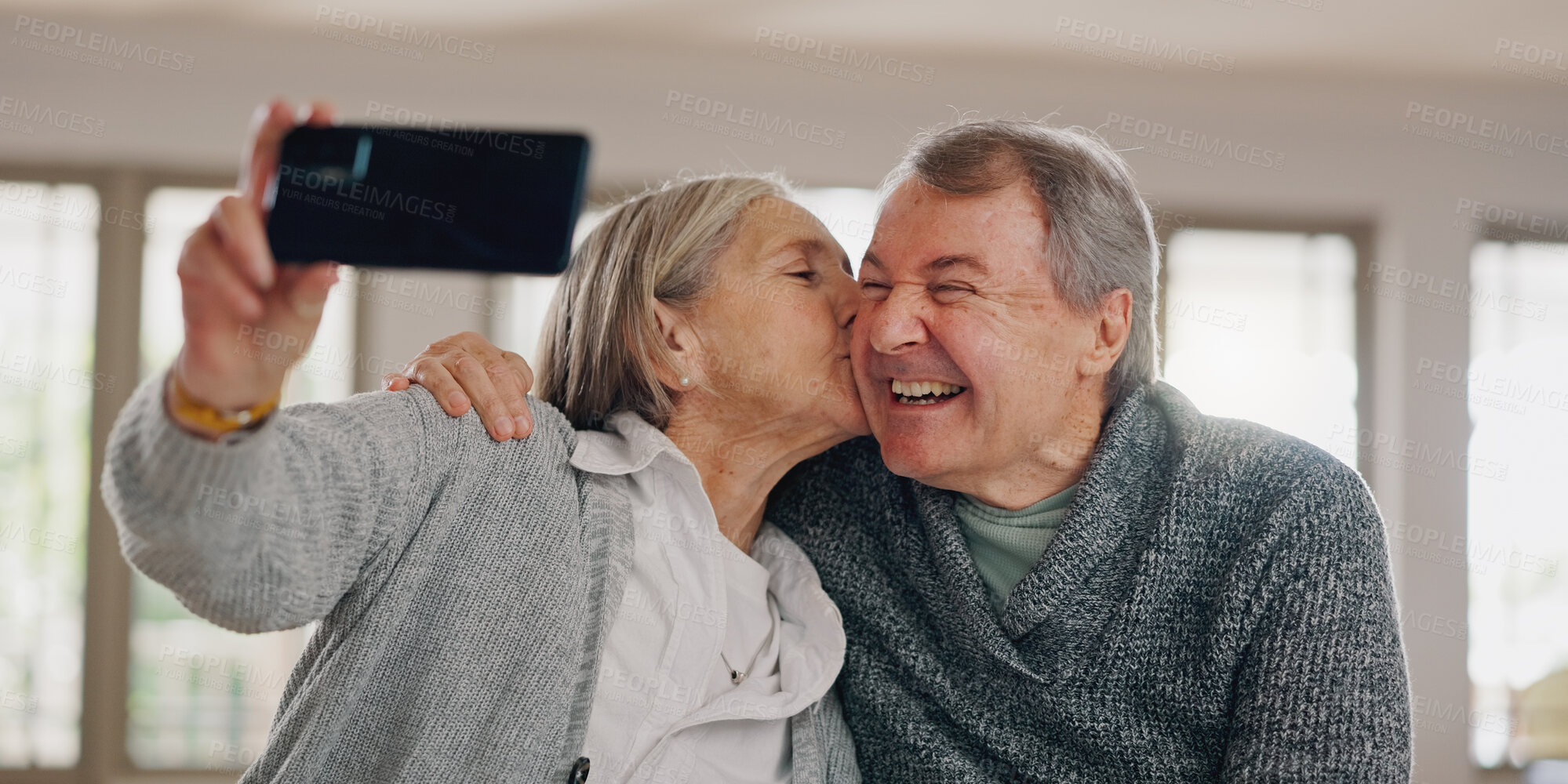 Buy stock photo Senior couple, selfie and kiss in home, photography and online for social media post in living room. Elderly people, happy and laugh for affection in relationship, love and profile picture for memory