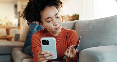 Buy stock photo Phone, credit card and African woman checking info at home with online shopping, deal and website. Living room, sofa and relax with internet bank app and ecommerce with digital purchase and mobile