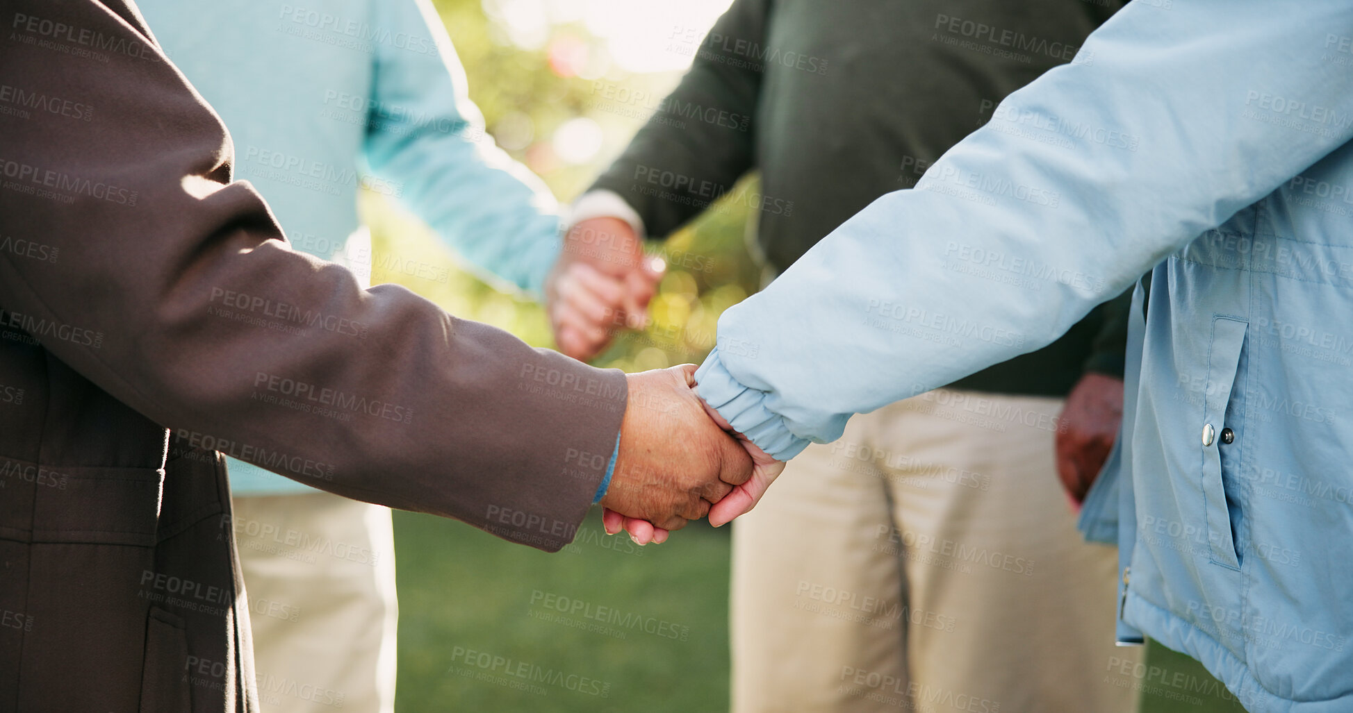 Buy stock photo Old people, outdoor and holding hands for prayer, support and motivation with spiritual in park. Social gathering, group and friends with closeup, religious and faith with peace, bonding together