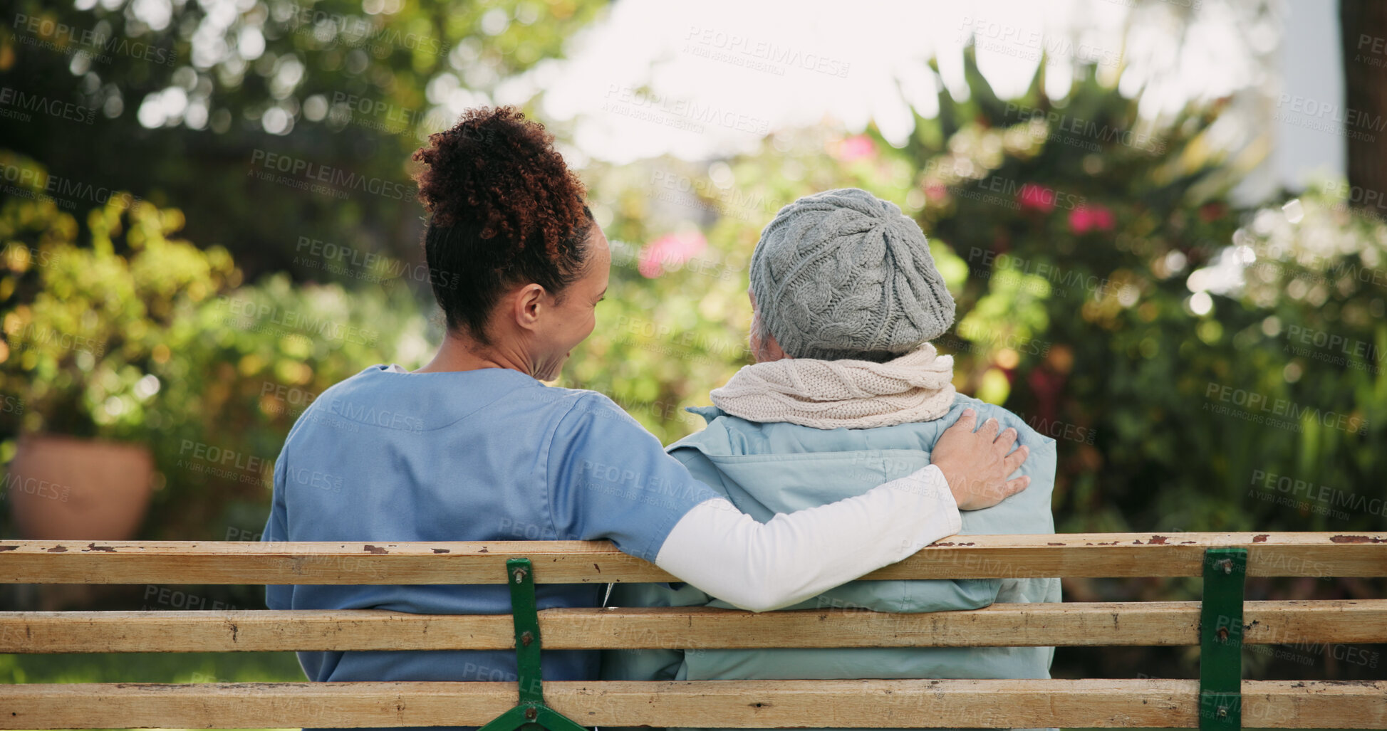 Buy stock photo Volunteer, senior woman and hug on bench outdoor for nursing support, retirement and comic conversation. Back, caregiver and people with embrace for wellness assistance, empathy and residential care