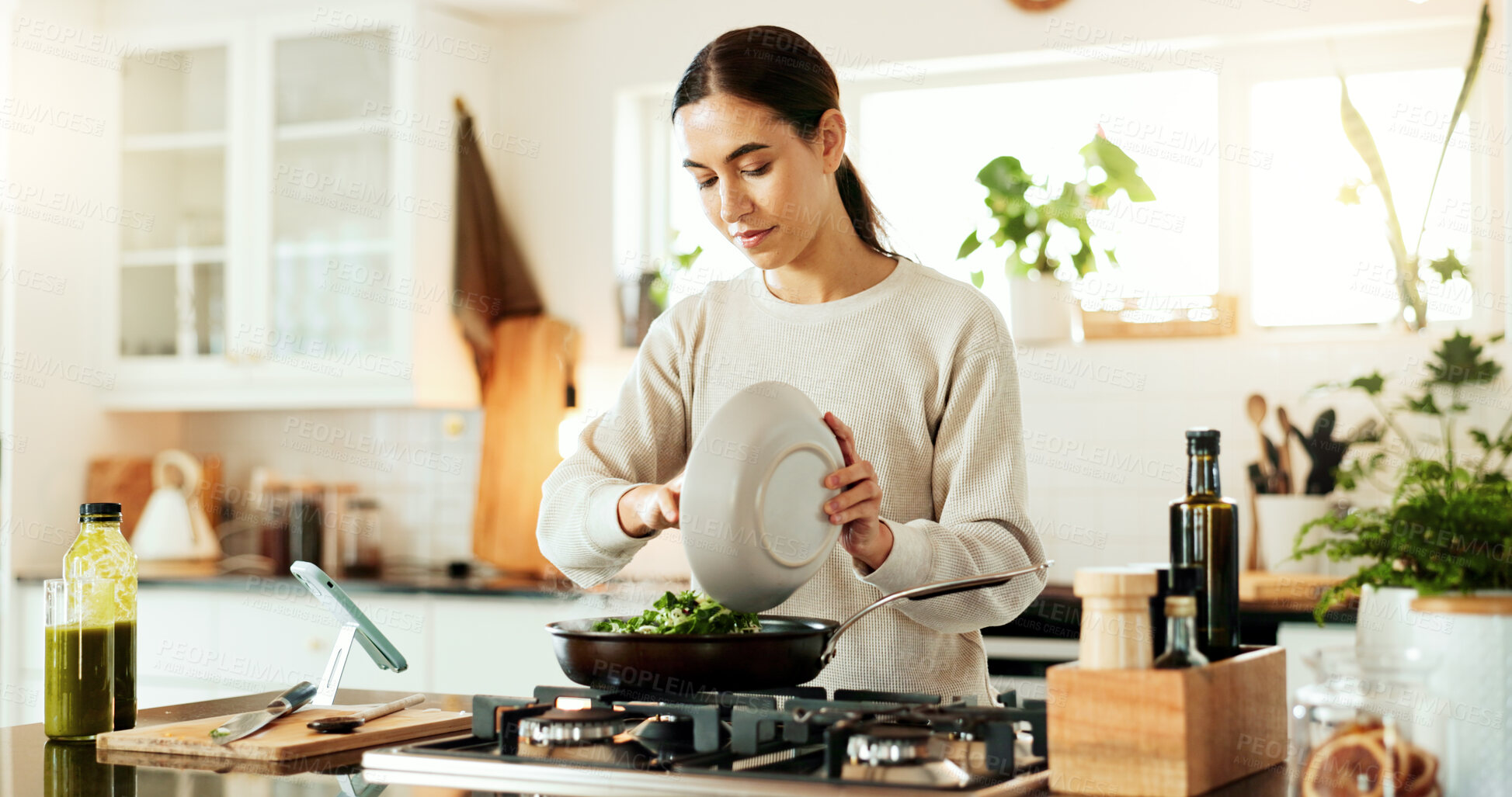 Buy stock photo Woman, cooking and green salad in kitchen with phone for live streaming, online recipe and meal prep by stove. Nutrition influencer, food blogger or vegan chef with social media tutorial in apartment